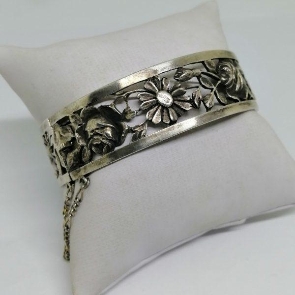Bracelet jonc argent ajouré avec motif de fleurs.