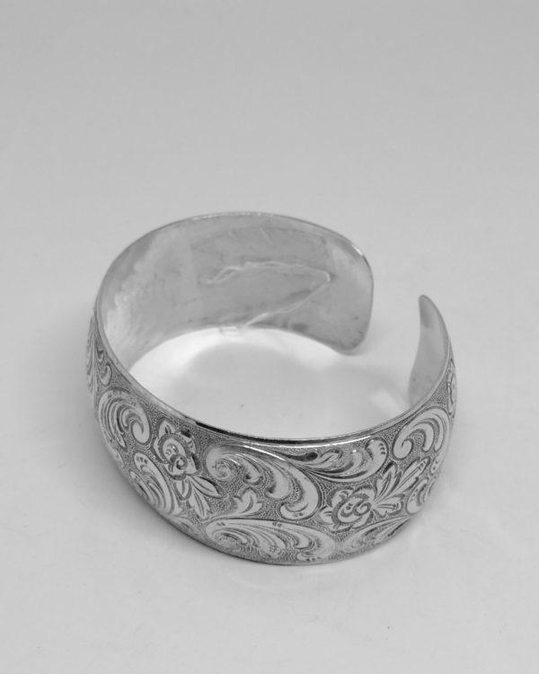 bracelet argent, jonc ouvert avec décor de feuillages et fleurs vers 1920.