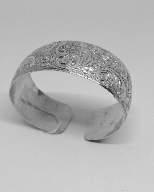 bracelet argent, jonc ouvert avec décor de feuillages et fleurs vers 1920.