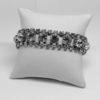 Bracelet en métal blanc avec pavage de strass blanc.