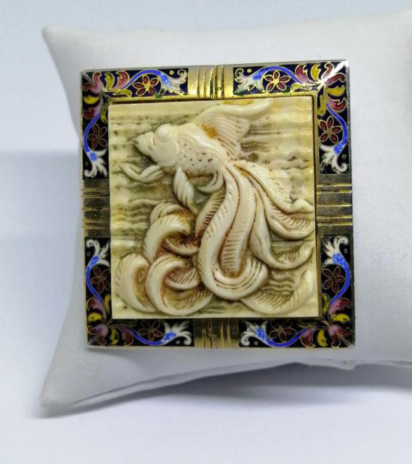 Broche en laiton, centre décor poisson japonisant, et cadre émaillé.