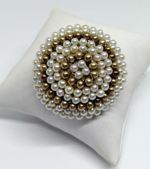 Broche monture laiton totalement sertie de perles bicolore.