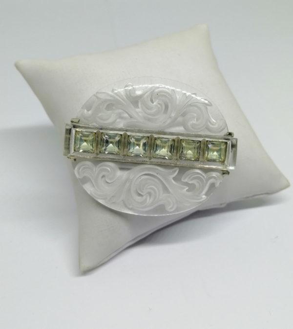 Broche en plexis ovale, et strass carré.
