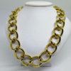 Collier gros maillon en métal jaune doré, signé de la marque Monet.