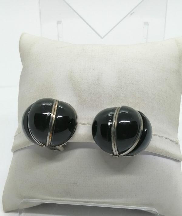 Boucles d'oreilles clip, métal blanc et verre noir en cabochon.