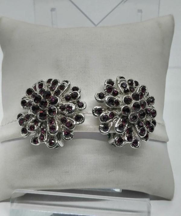 Boucles d'oreilles clip en métal blanc et pavage de strass violet.