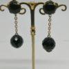 Boucles d'oreilles pendantes, clip en laiton avec cabochon et perle de verre noir à facettes.