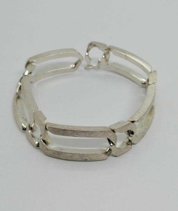 Bracelet argent, grosse maille longue et effet brossé sur l'extérieur.