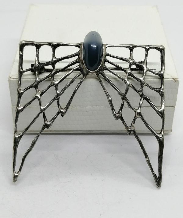 Broche argent, façon chauve-souris très stylisée, et cabochon de pierre.