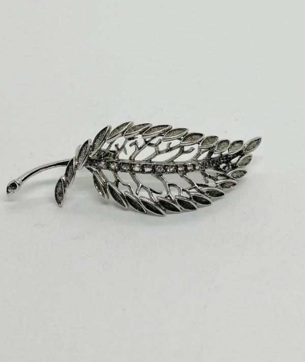 Broche argent , feuille galbée et sertie de pierres blanche.