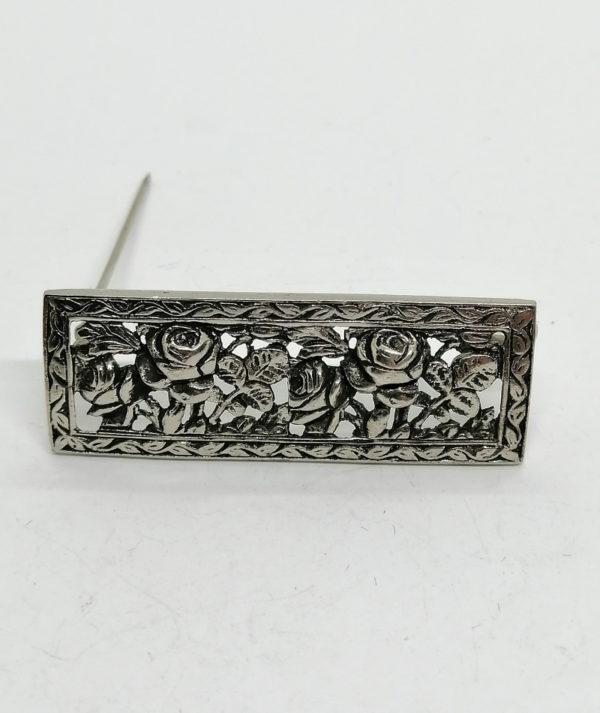 Broche argent de forme rectangulaire et motifs de roses stylisées.