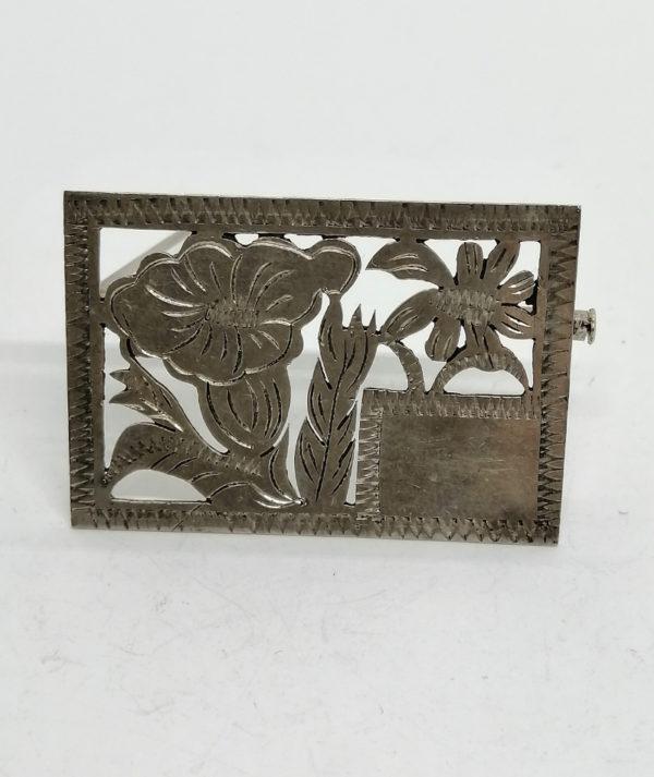 Broche argent en plaque, motifs de fleurs découpées et cartouche.