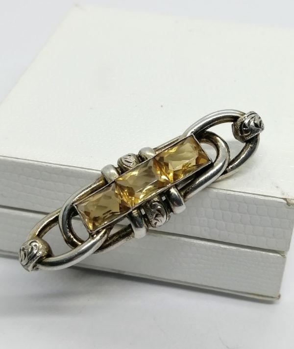 Broche argent, anneaux entrelacés, sertie d'un rang de citrines naturelles.