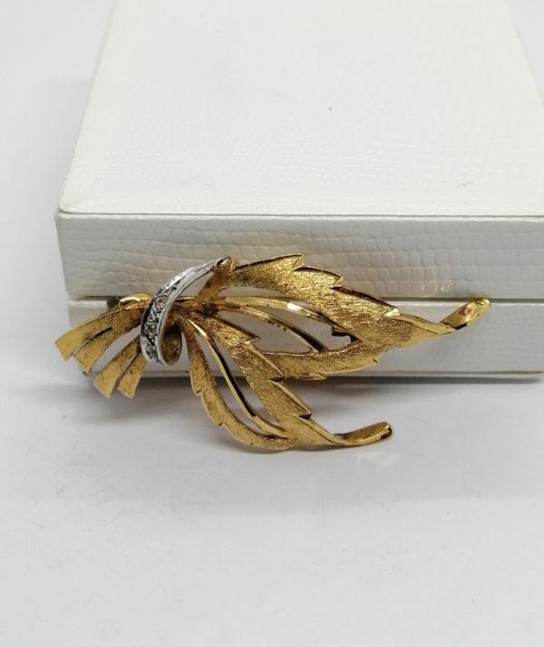 Broche argent vermeil, façon feuilles stylisées et ruban, sertie de pierres.