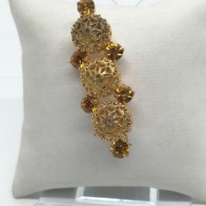 Broche fantaisie en laiton jaune et strass orangé, vers 1930