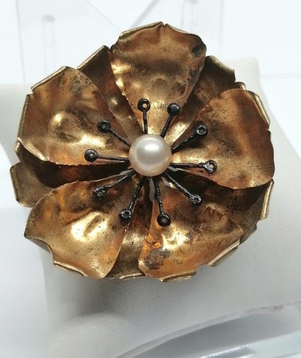 Broche en forme de fleur façonné en laiton jaune et perle.