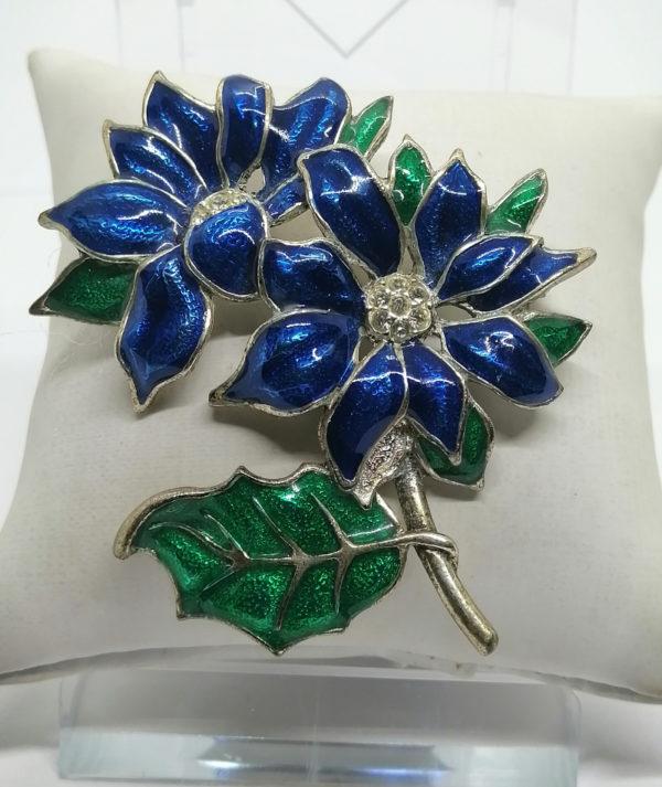 Broche réprésentant deux grosses fleurs et feuilles émaillées.