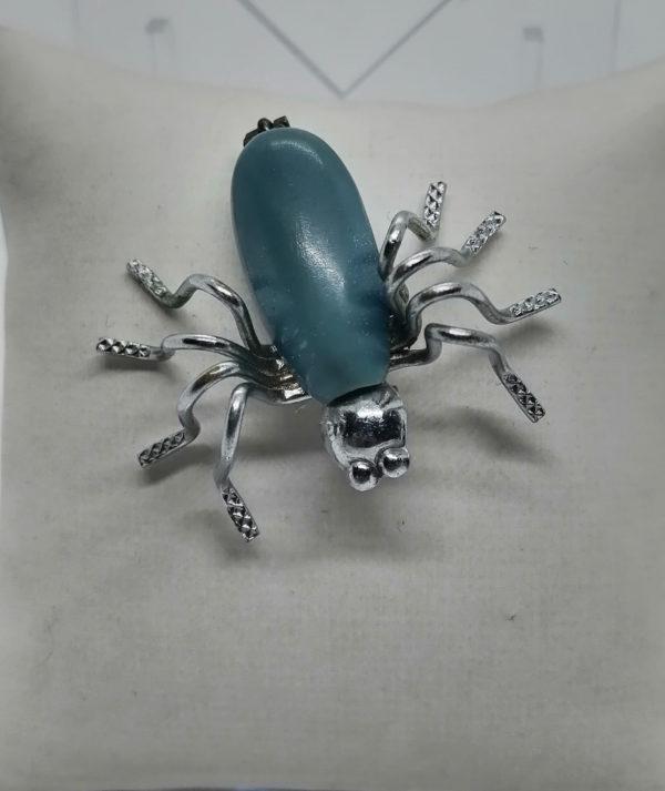 Broche araignée, en métal blanc et bakélite.
