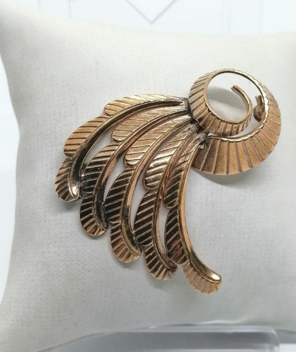Broche façon plumes stylisées en plaqué or.