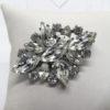 Broche en métal, ajourée et pavage de strass blanc avec navettes.