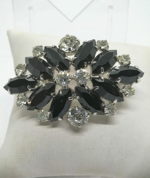 Broche pavage de strass blanc et noir sur métal blanc.
