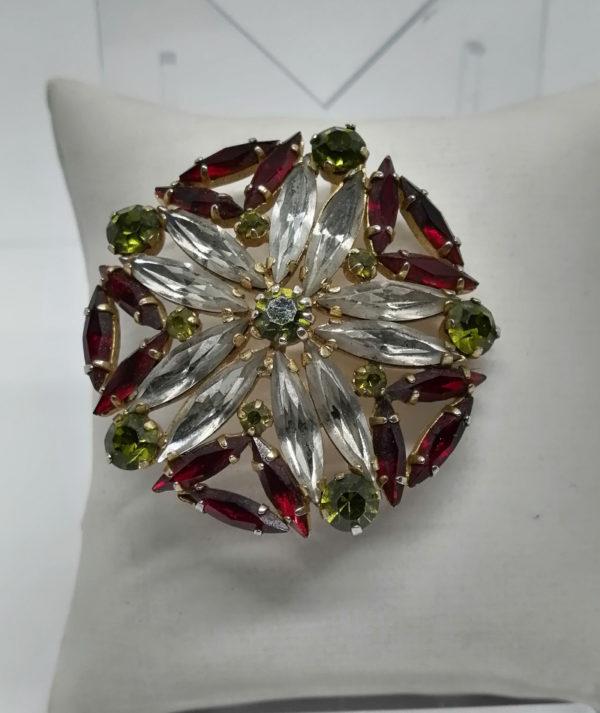 Broche ronde ajourée et pavage de strass en forme de navettes.