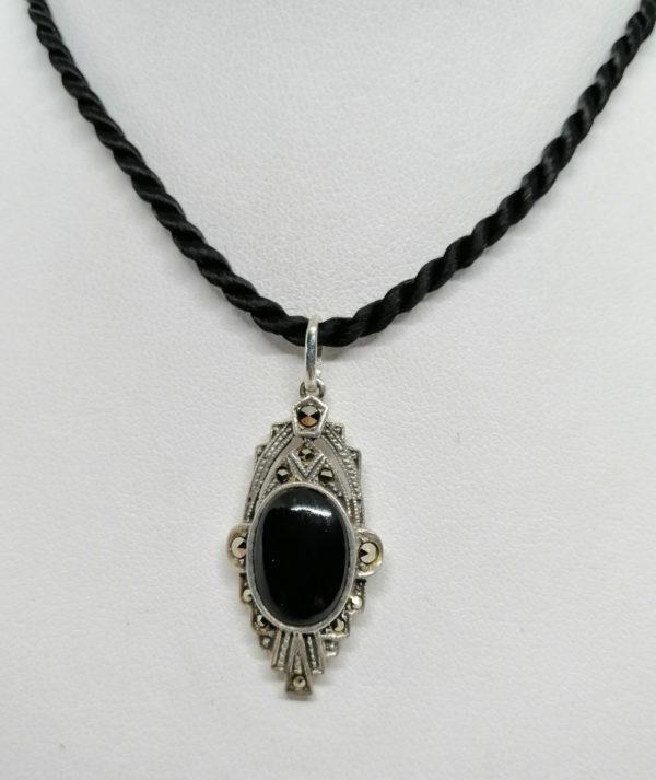 Pendentif argent, de forme structuré, pavage marcasites, au centre un cabochon d'onyx, Art Déco.