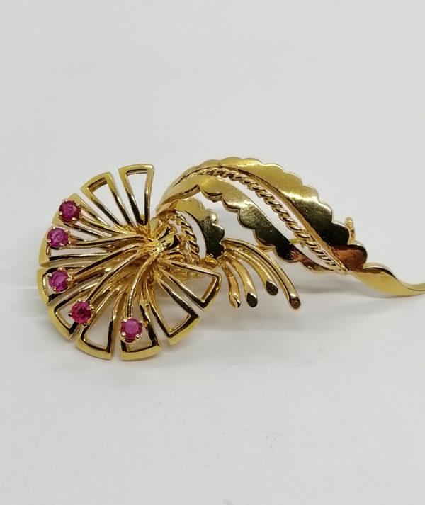 Broche en or, fleur stylisée et feuille, sertie de petits rubis, 1940-50.