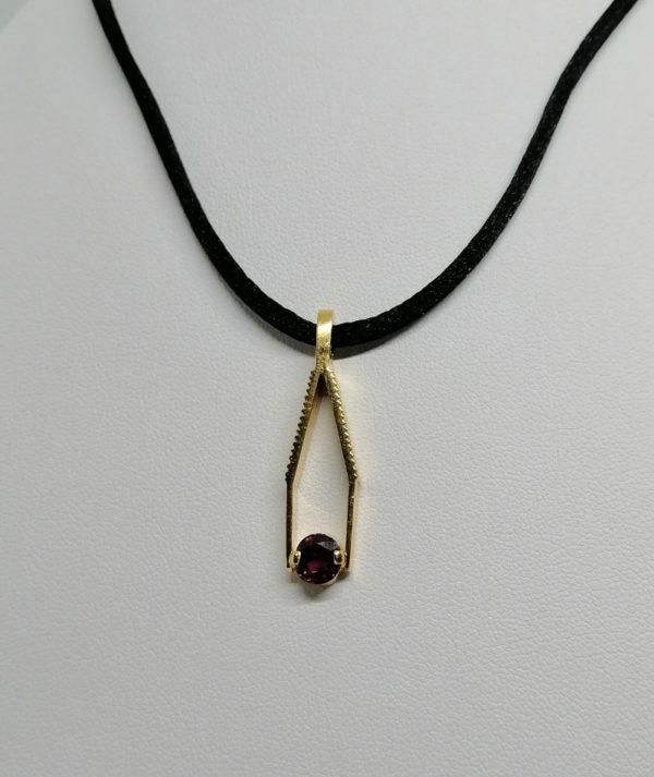 Pendentif en or, représentant une mini-pince de bijoutier, retenant une tourmaline rose.