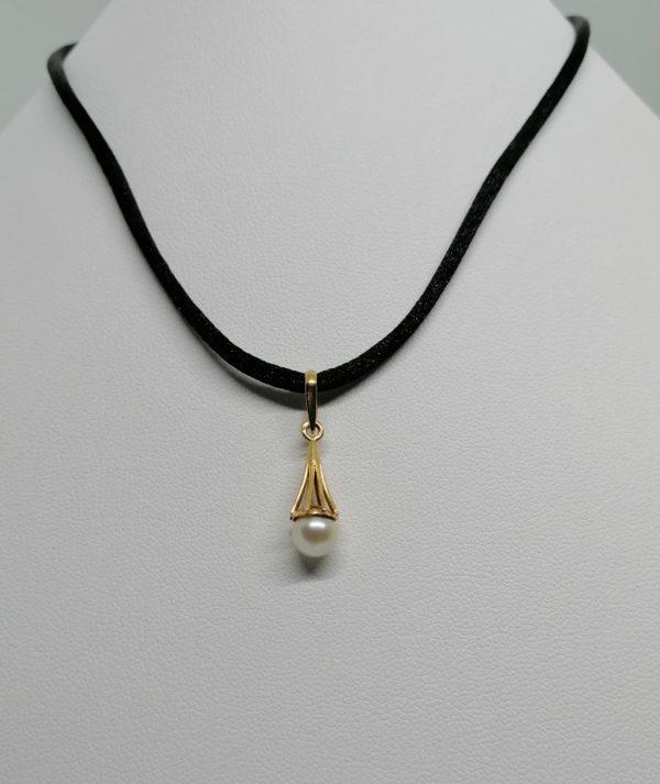 Pendentif en or jaune, pampille de forme conique et ajouré retenant une perle de culture.