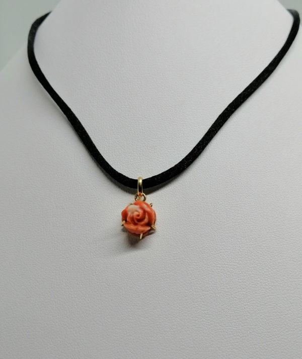 Petit pendentif en or, représentant une rose en corail sculptée.