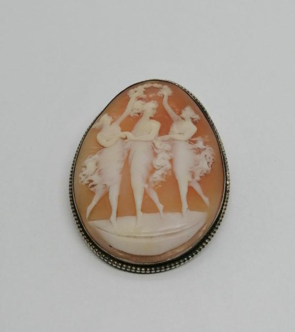 Broche argent, avec camée représentant trois femme et une couronne de fleurs.