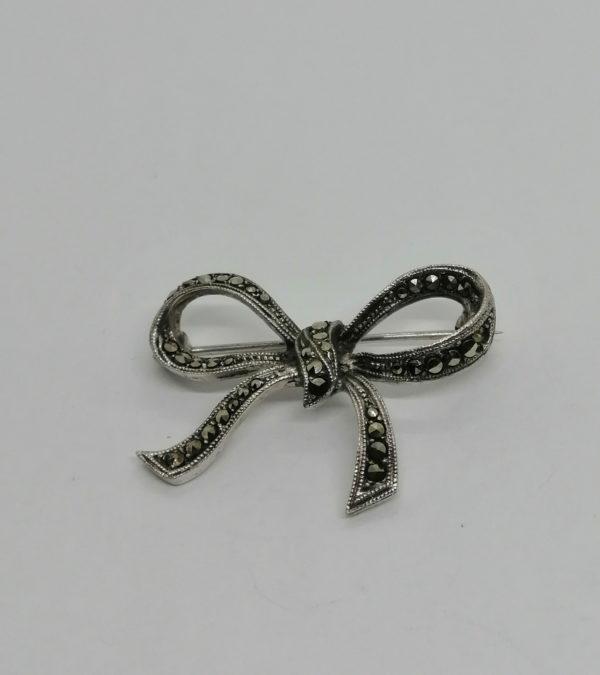 Broche argent, petit noeud pavé de marcasites, vers 1930.