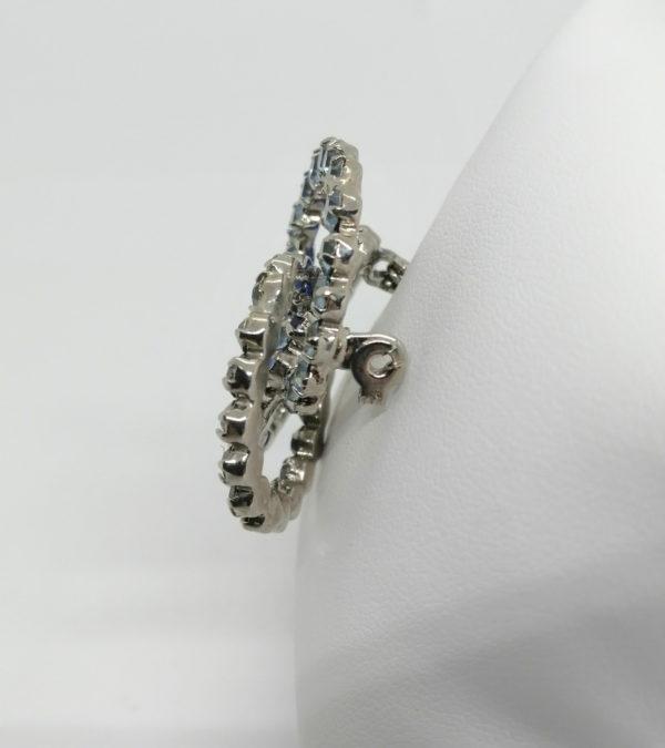 Broche en métal blanc, avec trois anneaux entrelacés et strass bleu. – Image 2