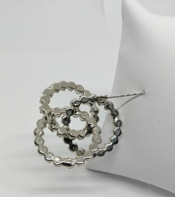 Broche en métal blanc, avec trois anneaux entrelacés et strass bleu. – Image 3