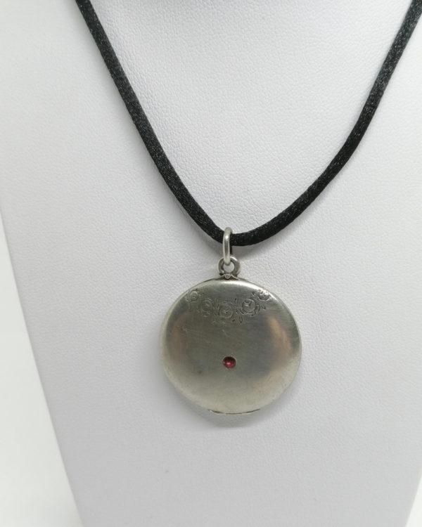 Pendentif argent, porte-photo, rond sobre fleur et petite pierre, 1900-20.