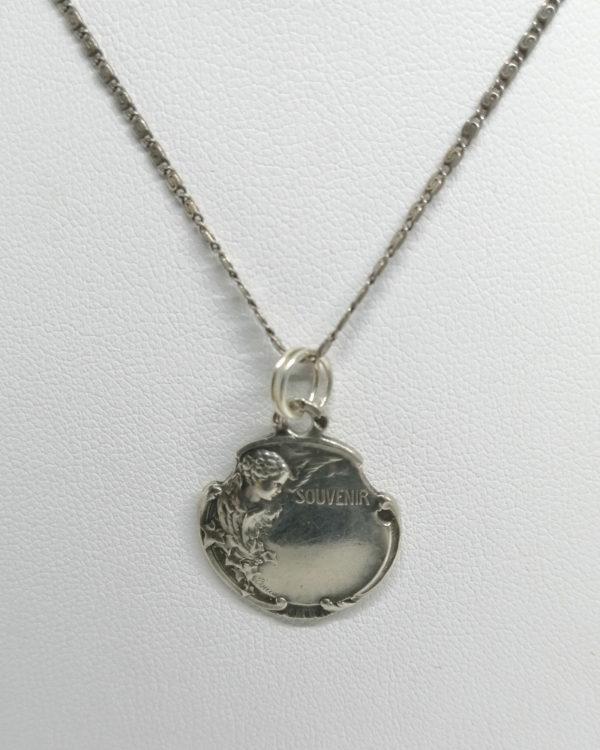 Pendentif argent, médaille souvenir avec angelot, et végétation, signé, Art Nouveau vers 1900.