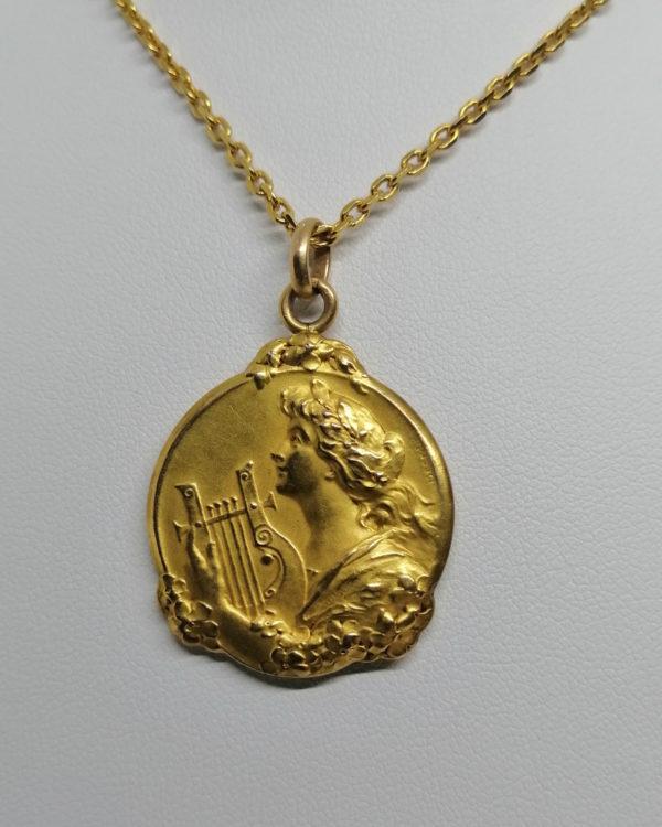 Pendentif en plaqué or, jeune femme à la lyre, signé Becker, Art Nouveau vers 1900.