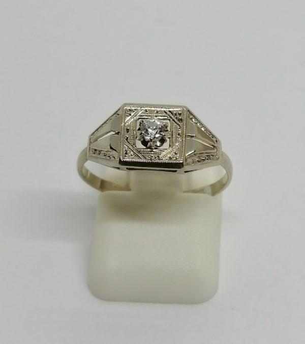 Bague or gris, modèle structuré et ajouré, avec saphir blanc facetté, vers 1930.