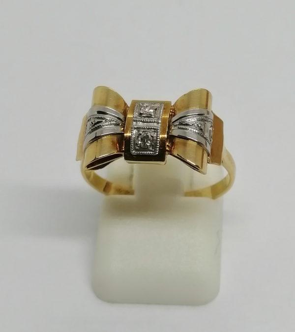 Bague or jaune et sertie platine, façon noeud papillon, vers 1925.