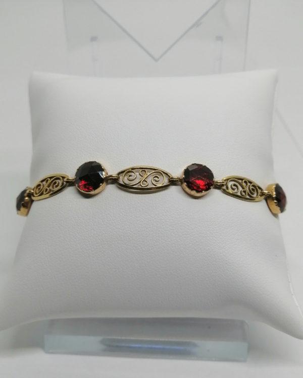 Bracelet or jaune, filigrané et sertie clos sur paillon de grenats taillés, vers 1900.