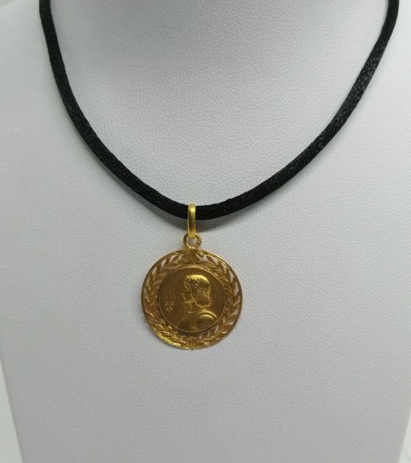 Pendentif en or jaune, rond et ajouré de feuillages avec Jeanne d'Arc, vers 1900.