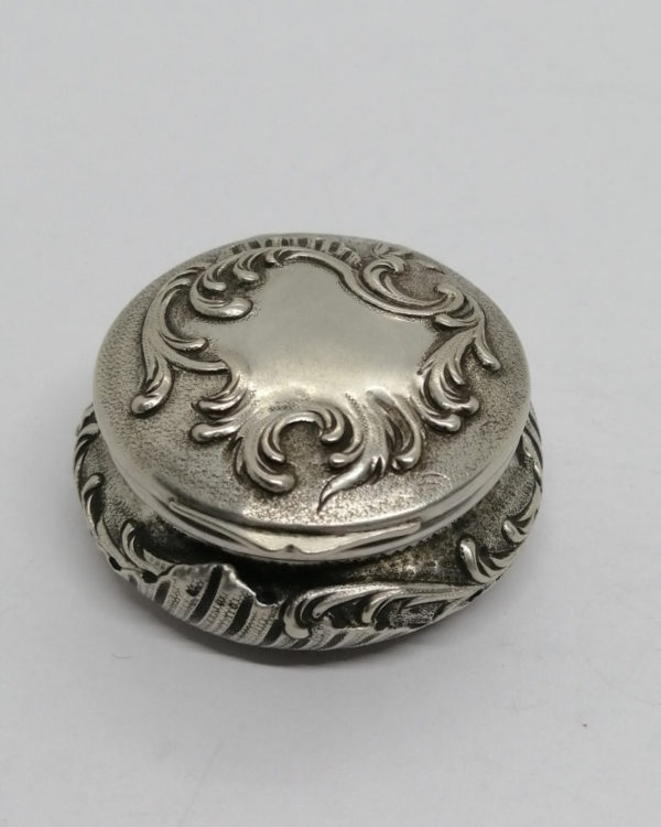 Boîte à pilules, argent massif, décor rocaille sur fond travaillé, Art Nouveau, Paris vers 1900.