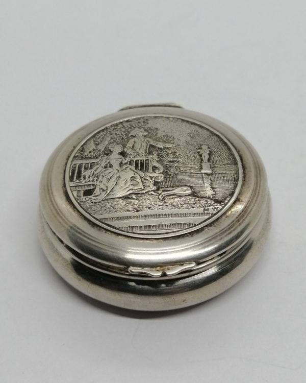 Boîte à pilules argent massif, décor d'une scène galante dans parc, 1920.