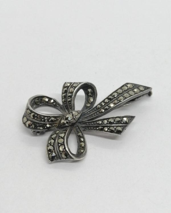 Broche argent, noeud ruban, pavage marcasites, vers 1920.