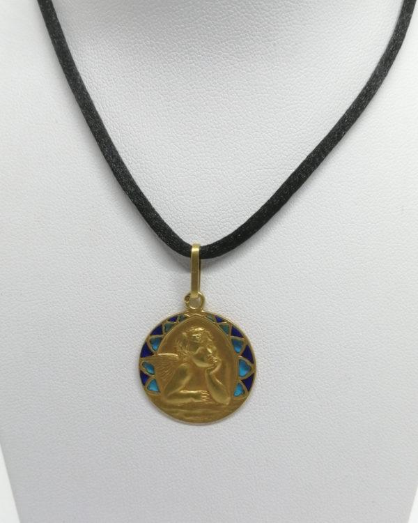 Pendentif or jaune, médaille avec angelot et émail plique à jour, vers 1900.
