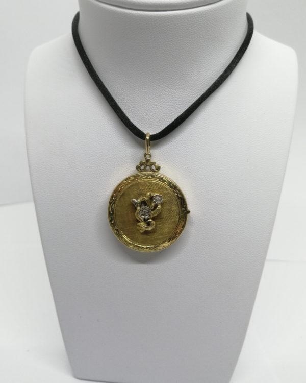 Pendentif or jaune, double porte-photo, guilloché et diamants, vers 1920.
