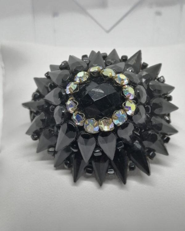 Broche en hauteur pavage de pâte de verre noir et strass, 1920-30.