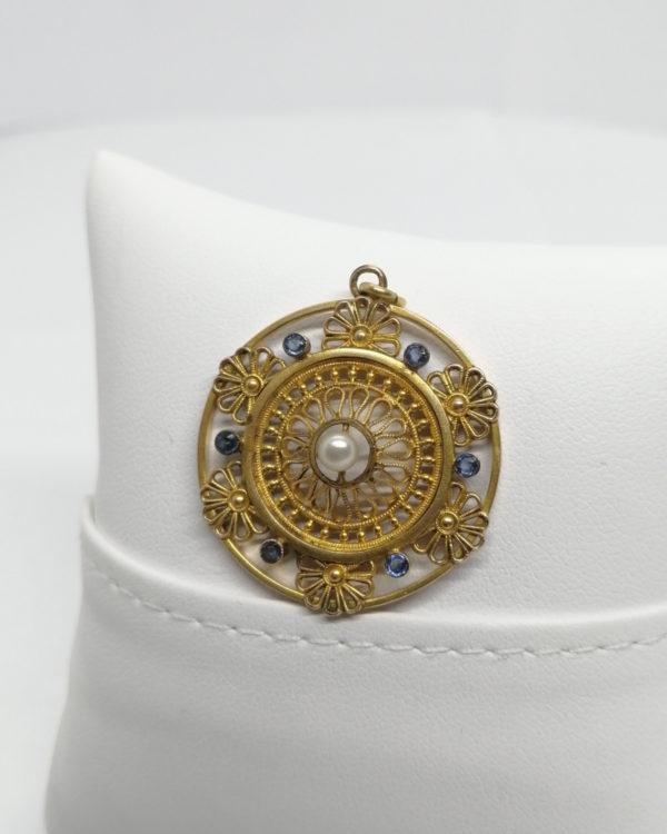 Pendentif plaqué or, ajouré, sertie de pierres bleu et une perle d'imitation, 1925-30.