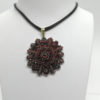Pendentif en pomponne, et pavage de grenats taille bohême, vers 1890-1900.